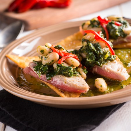 Tuna Tostada with Chimichurri on a tan plate