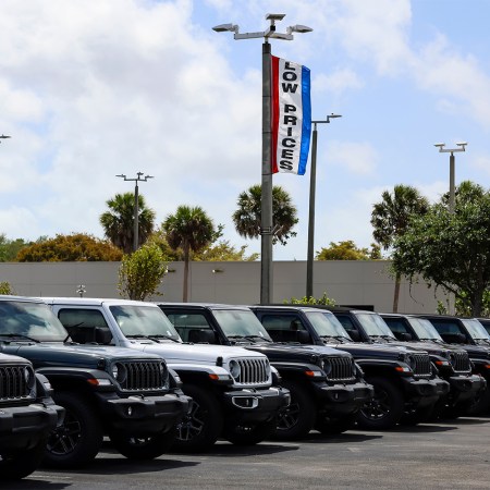 A U.S. car dealership with a flag on a light pole that reads "LOW PRICES." Thanks to Trump's tariffs, the entry-level market may be dealt a killer blow.