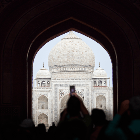A tourist taking a photo of the Taj Mahal with their camera phone